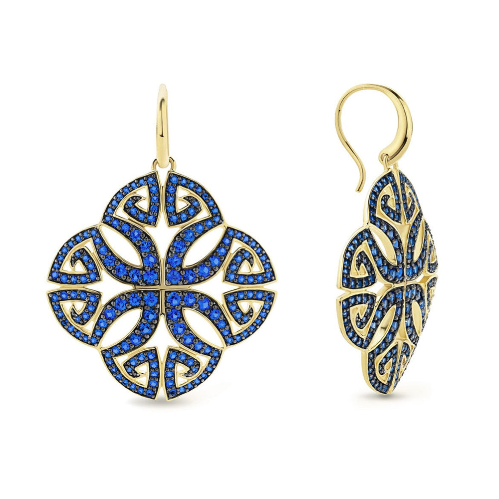Gold earrings with blue gemstones on a white background