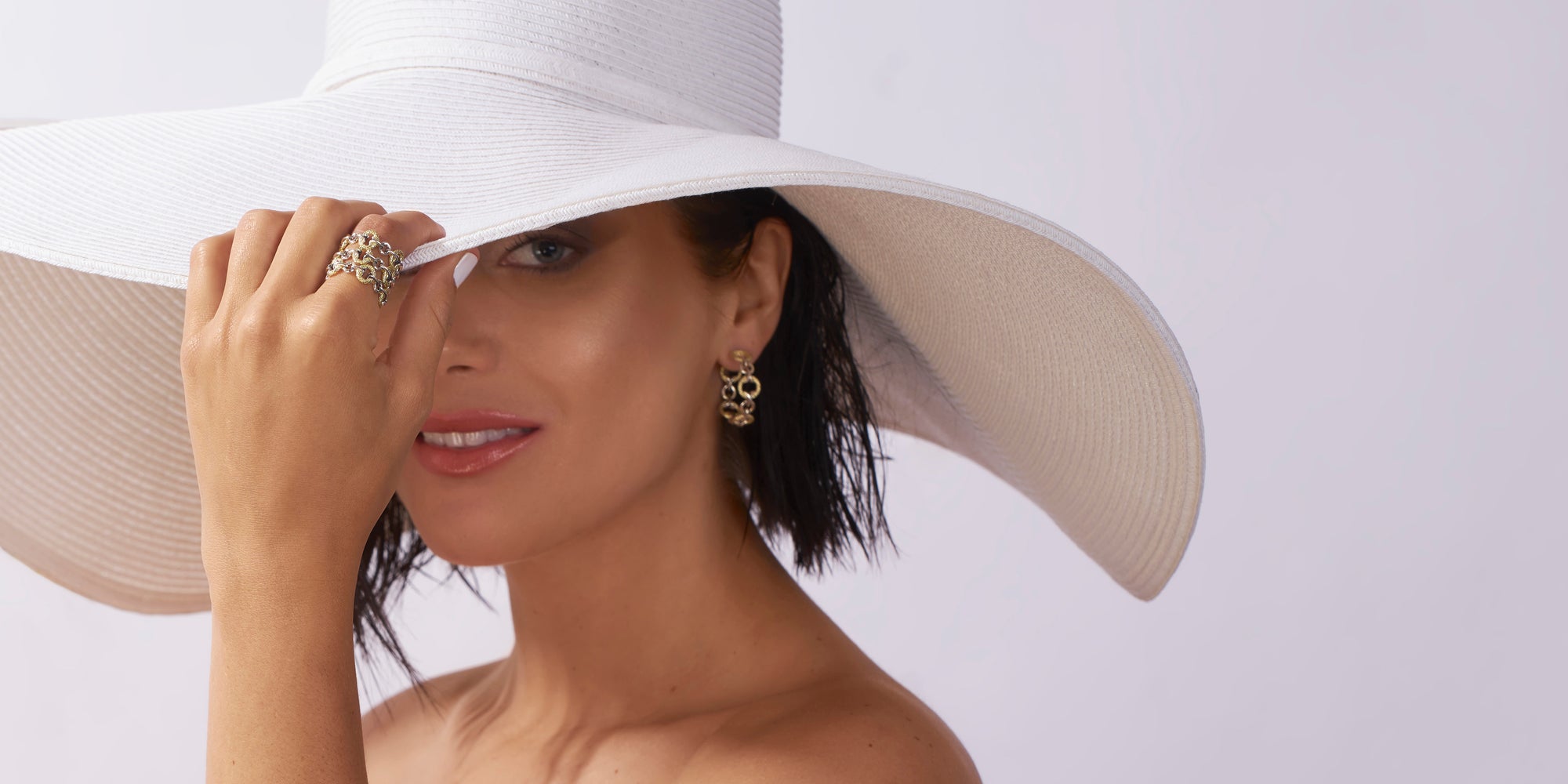 woman in dramatic white hat wearing REALM Fine + Fashion Jewelry TRYST Collection
