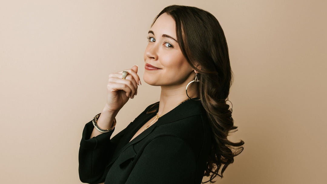 Gina Lizzo in black suit wearing REALM CZ Noir gold jewelry — Real Woman of REALM.