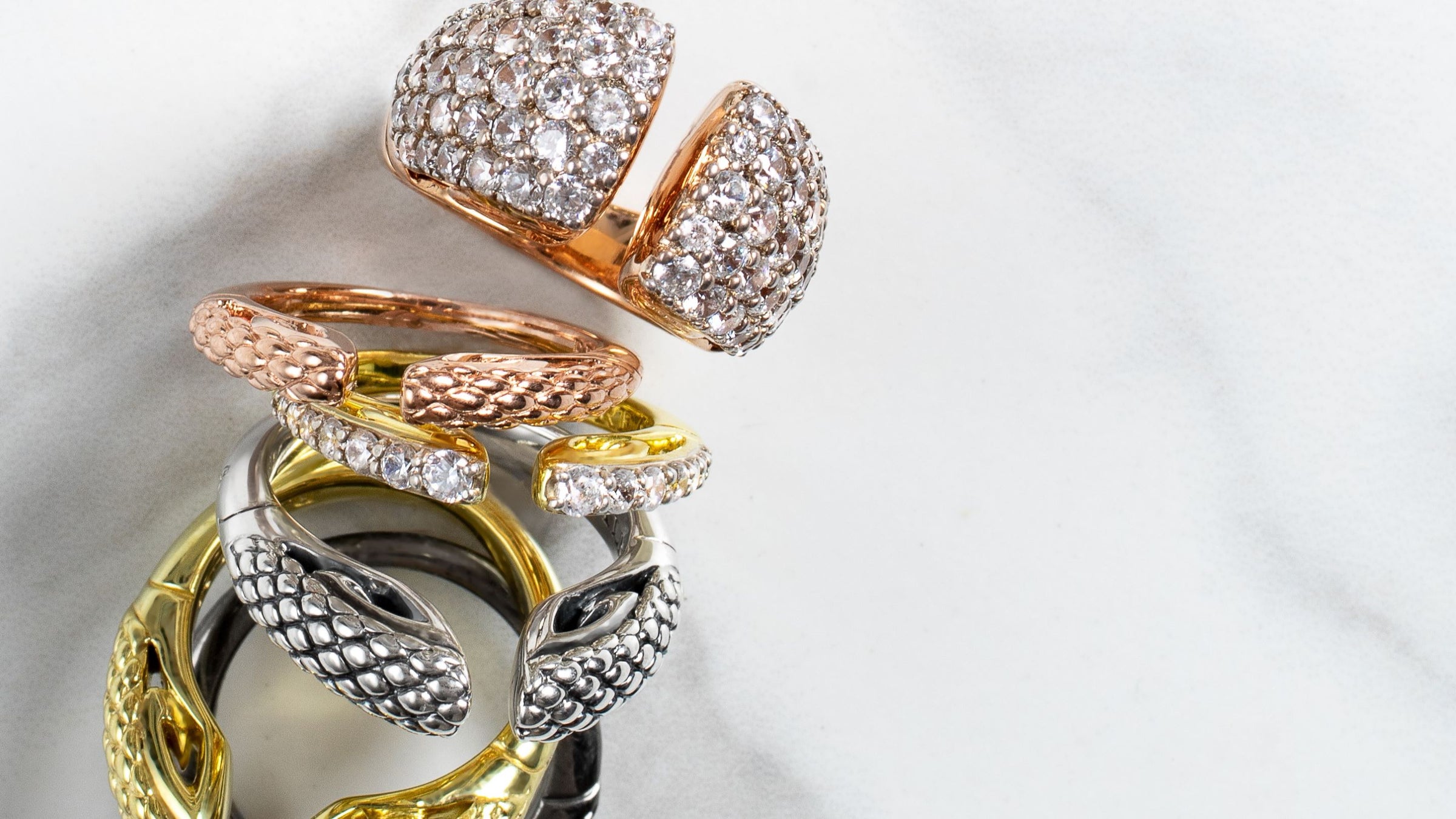 Array of luxurious stack rings in gold, silver, rose gold, black ruthenium and white cz
