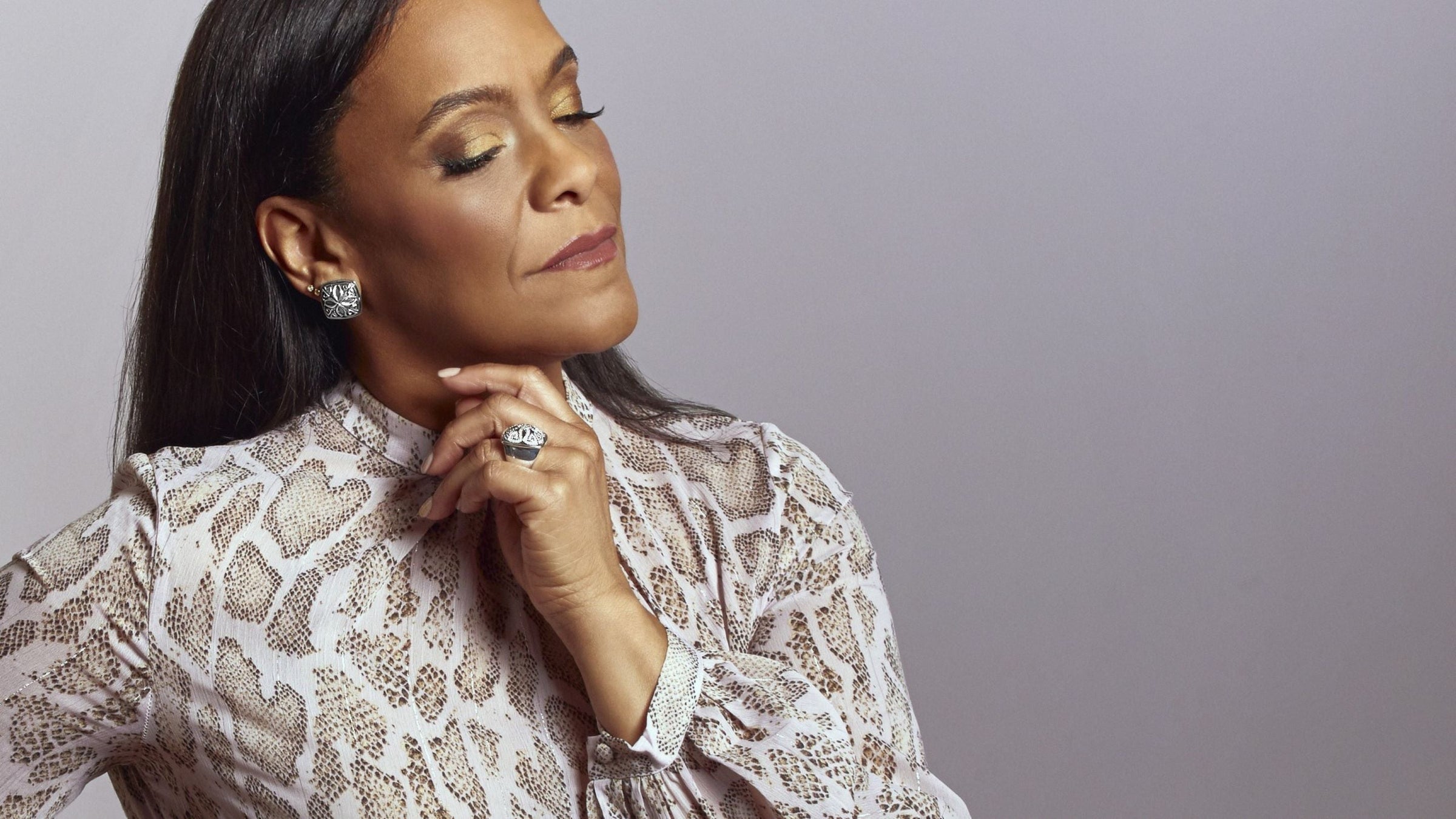 Richelle Payne, Real Woman of REALM, wearing a soft pastel leopard blouse styled with Sterling Silver styles from REALM Fine + Fashion Jewelry