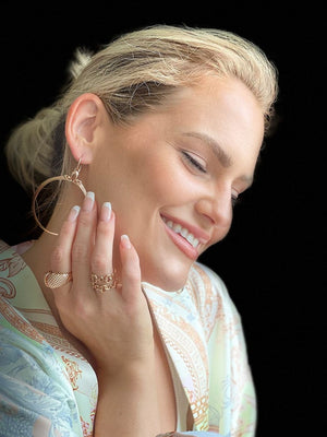 woman wearing robe and romantic rose gold jewelry from REALM