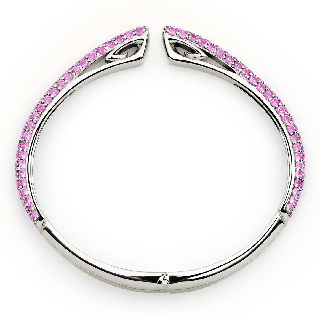 Silver bangle with pink gemstones on a white background