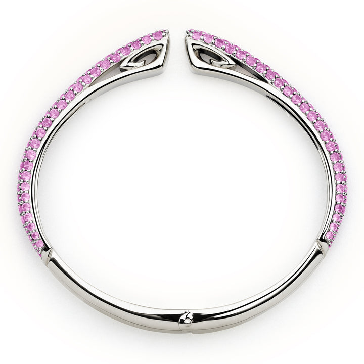 Silver bangle with pink gemstones on a white background