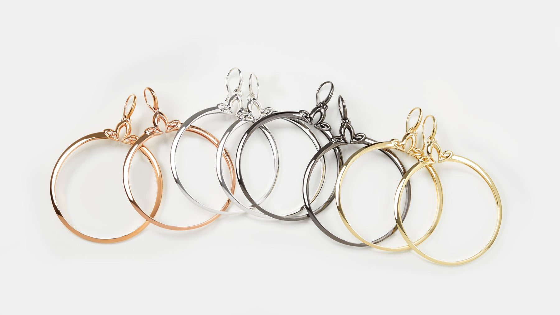 array of large portrait hoop earrings in rose gold, sterling silver, black ruthenium and gold