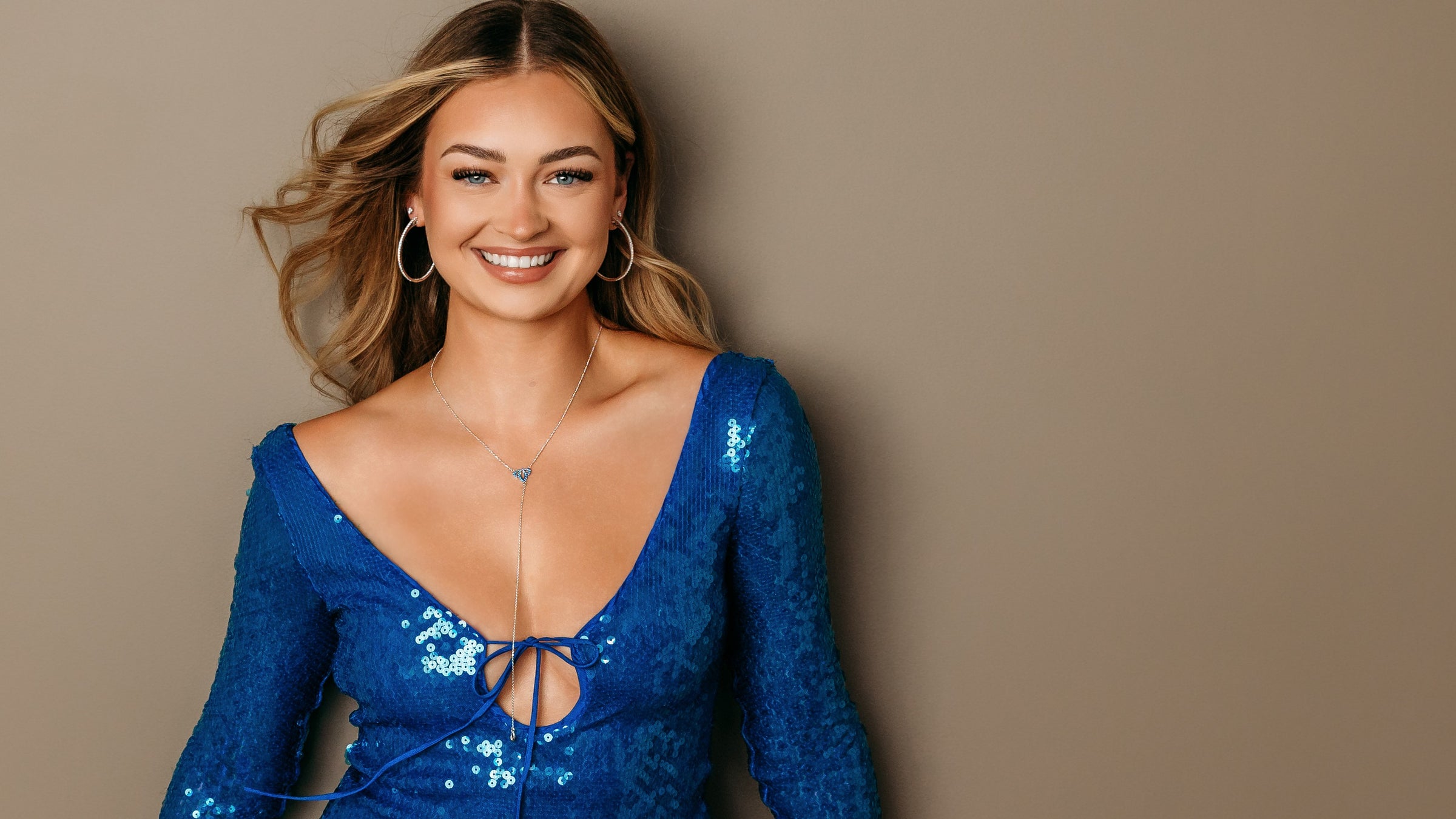 Woman in blue sequin dress wears new jewelry styles