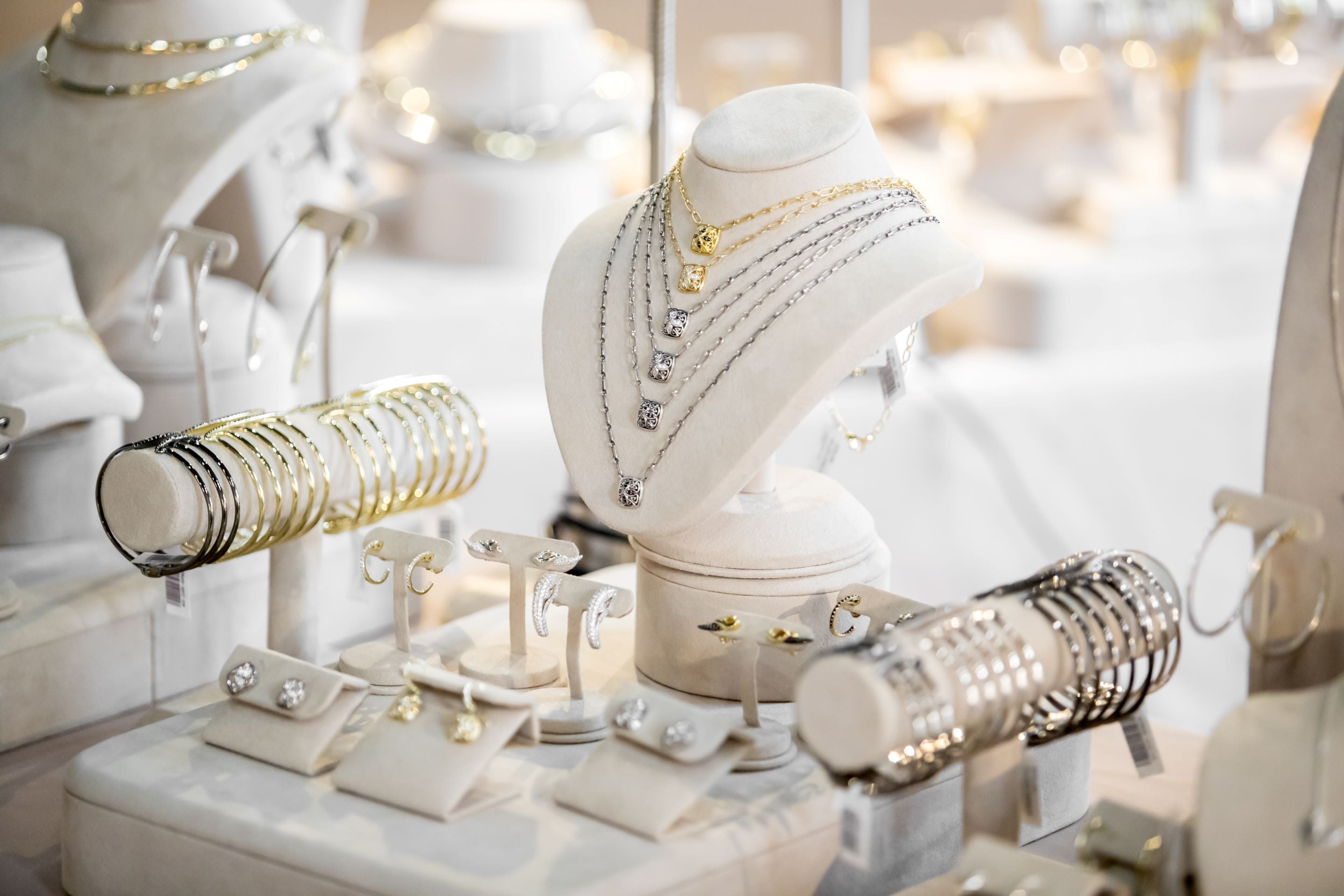 dramatic array of necklaces bracelets earrings rings in precious metals from REALM Fine + Fashion Jewelry