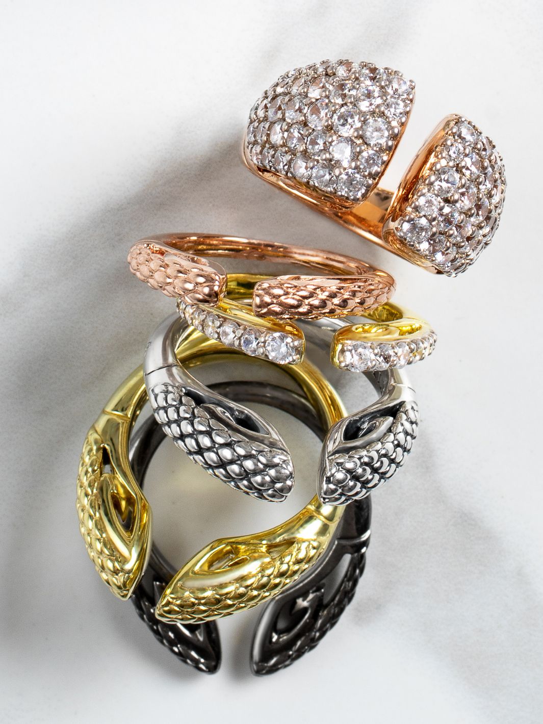 luxurious array of REALM stack rings in gold, rose gold, sterling silver and black ruthenium